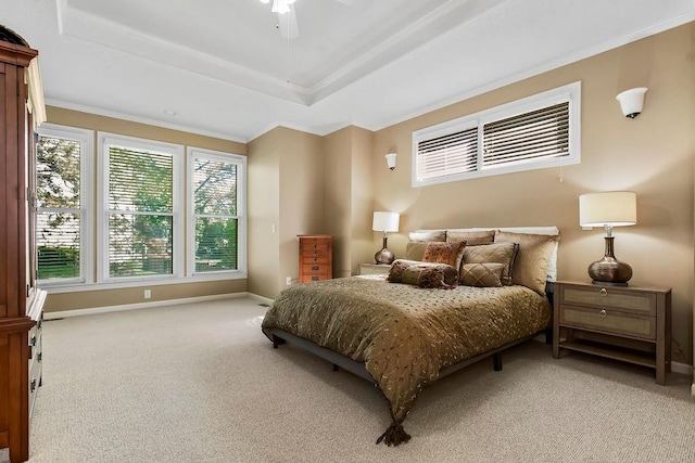 bedroom with light colored carpet, ornamental molding, baseboards, a tray ceiling, and a ceiling fan