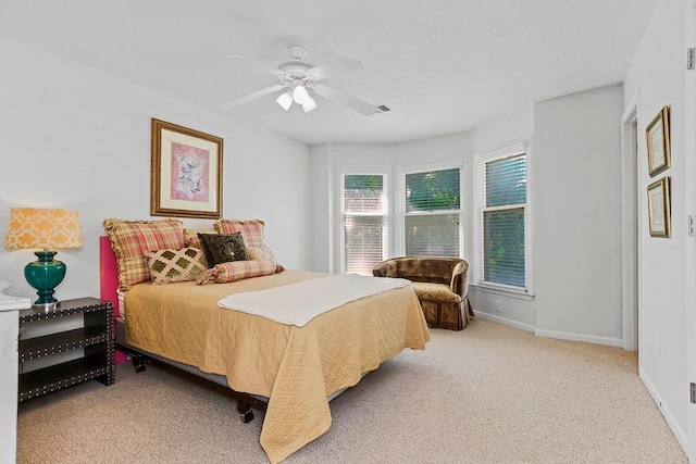 bedroom with light colored carpet, baseboards, and ceiling fan