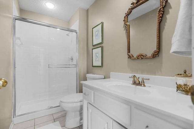 bathroom featuring toilet, a textured ceiling, a stall shower, tile patterned flooring, and vanity