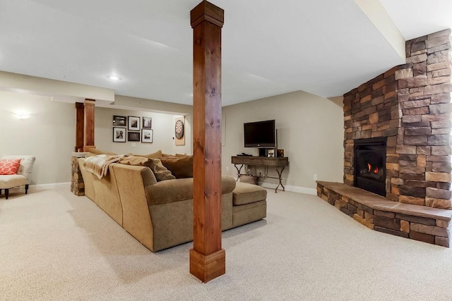 living area featuring carpet, a stone fireplace, and baseboards