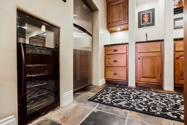 interior space with baseboards and bar with sink