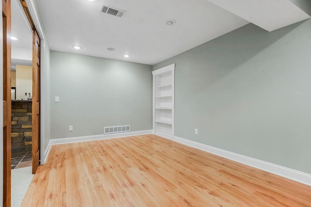 unfurnished room with light wood finished floors, baseboards, and recessed lighting