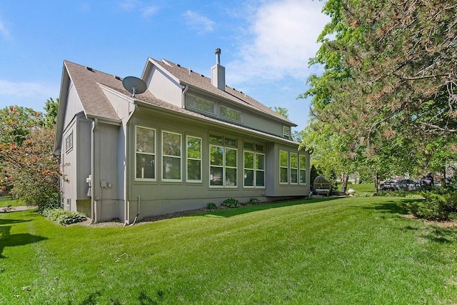 rear view of house with a yard and a chimney