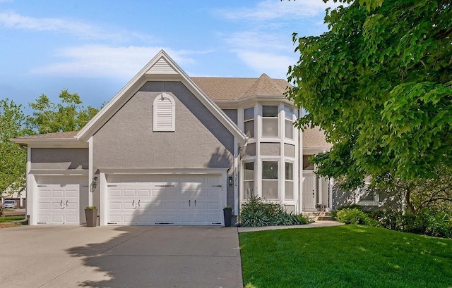 view of front of house with stucco siding, driveway, a front lawn, and a garage