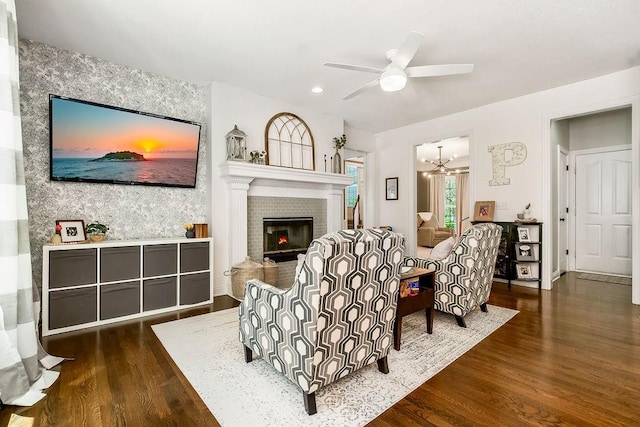 14327 King St, Overland Park, KS 66221 - living area featuring wood finished floors, a fireplace, ceiling fan, a chandelier, and an accent wall