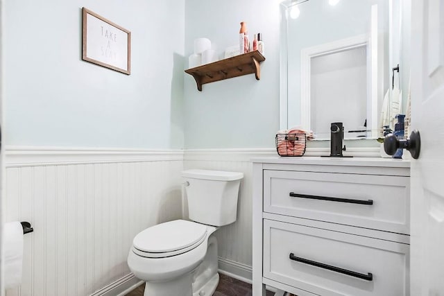 14327 King St, Overland Park, KS 66221 - half bathroom featuring vanity, toilet, wainscoting, and wood finished floors