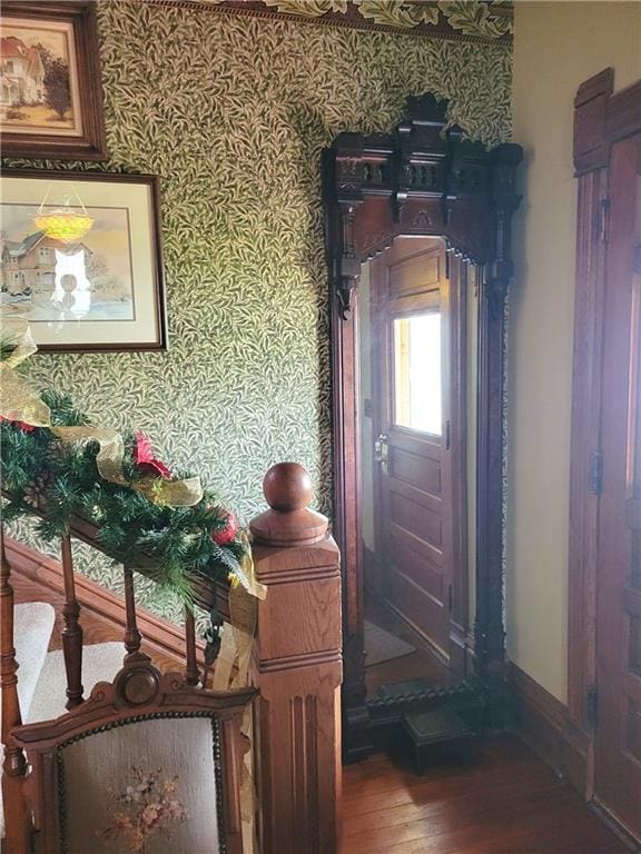 foyer entrance featuring baseboards, hardwood / wood-style floors, and wallpapered walls