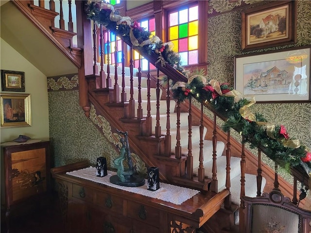 stairway featuring wallpapered walls and lofted ceiling