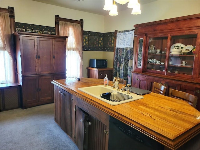 kitchen with a sink, black appliances, light carpet, glass insert cabinets, and a notable chandelier