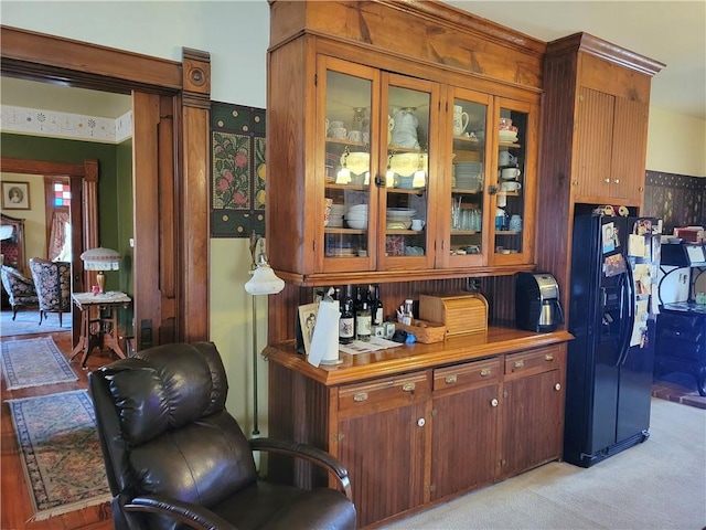 bar with light carpet and black refrigerator with ice dispenser