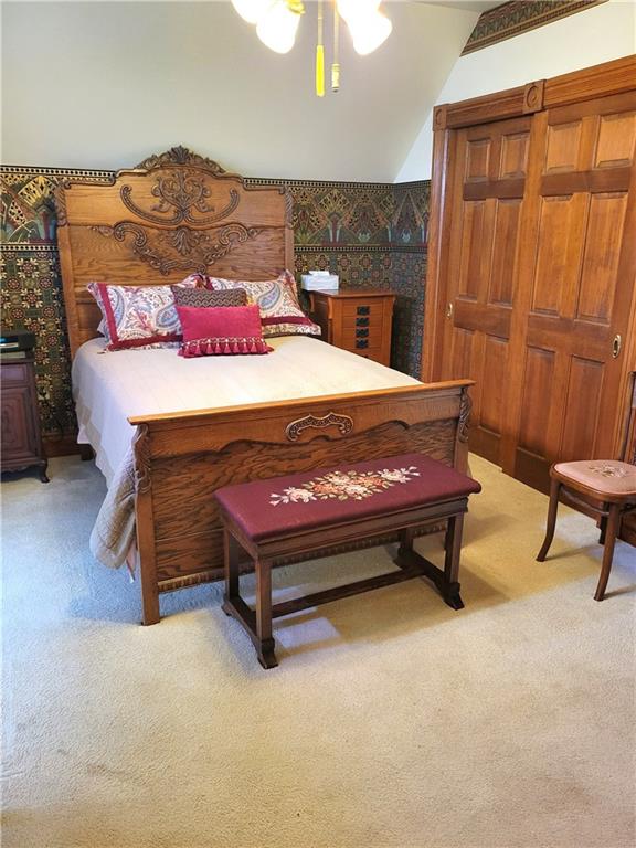 bedroom with light colored carpet, ceiling fan, and wallpapered walls