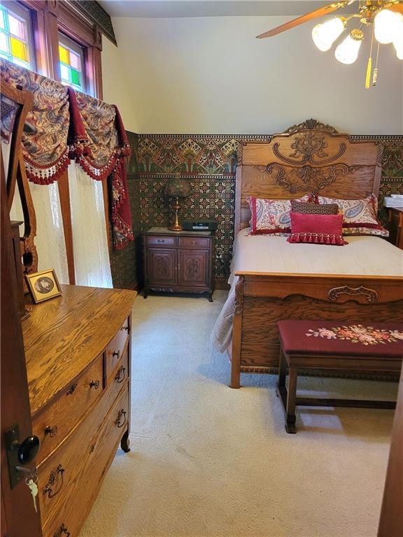 bedroom with light colored carpet and a ceiling fan