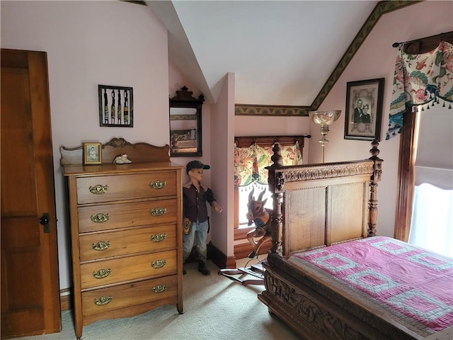 bedroom with light colored carpet and lofted ceiling
