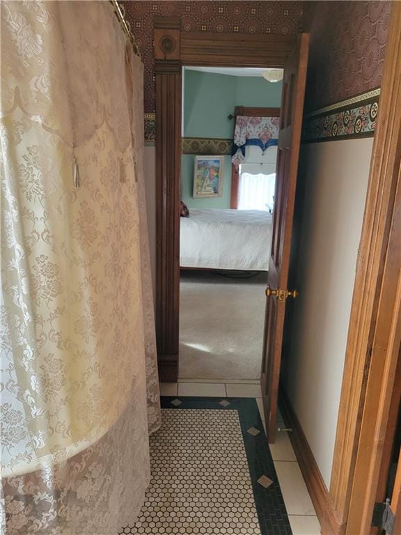 hallway with tile patterned floors and baseboards
