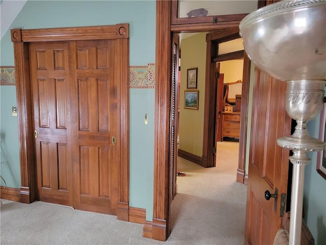 hallway with carpet flooring and baseboards