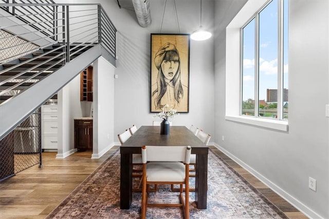 dining space with baseboards and wood finished floors
