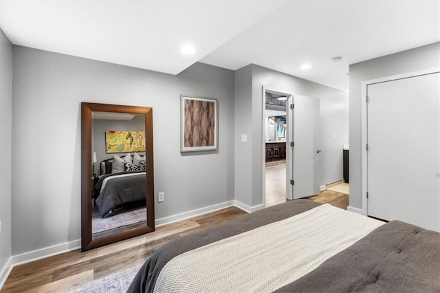 bedroom with baseboards, recessed lighting, and wood finished floors