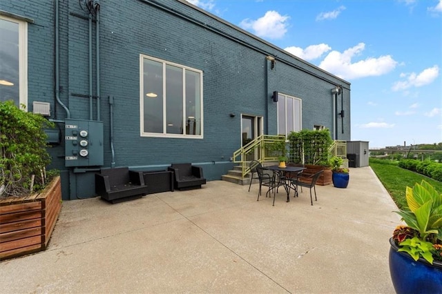 back of property featuring brick siding and a patio