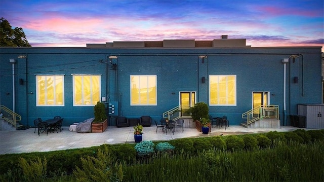 1605 Jefferson St, Kansas City, MO 64108 - back of house at dusk featuring entry steps and a patio