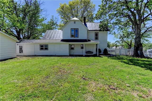 back of property with fence and a lawn