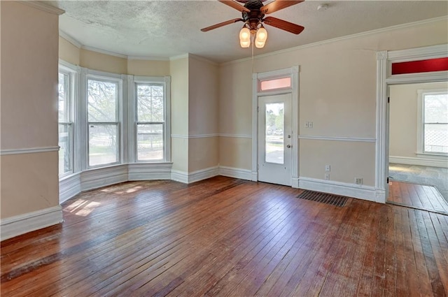 empty room with ceiling fan, plenty of natural light, crown molding, and wood-type flooring