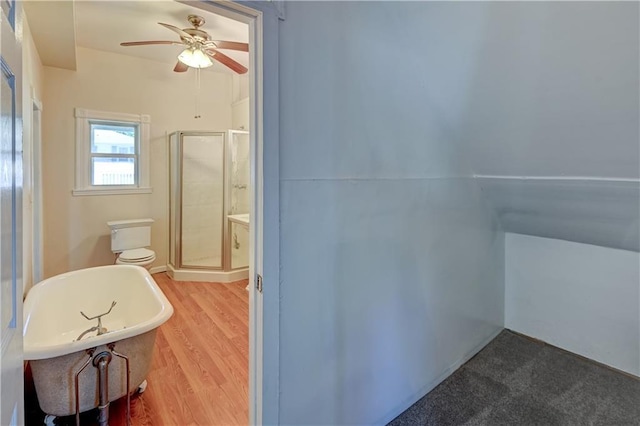 bathroom featuring a freestanding tub, ceiling fan, wood finished floors, and a stall shower