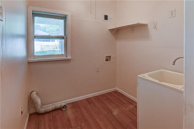 clothes washing area featuring wood finished floors, baseboards, laundry area, and visible vents