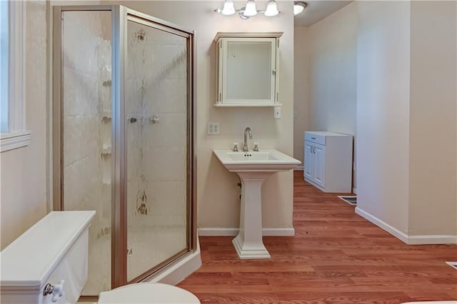 full bathroom featuring a shower stall, baseboards, and wood finished floors