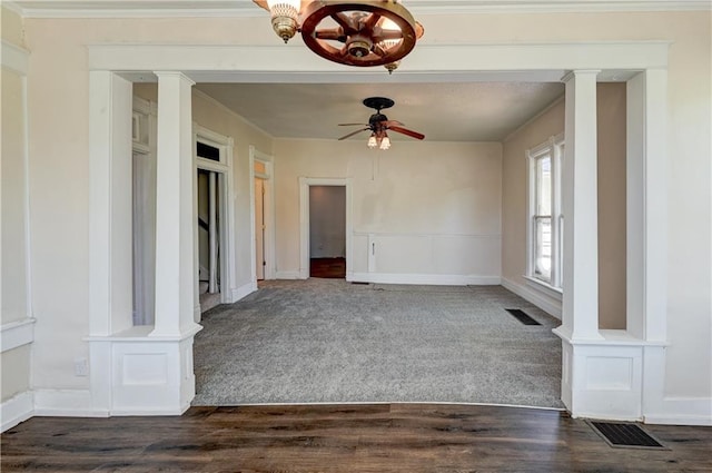 unfurnished room featuring dark colored carpet, ceiling fan with notable chandelier, crown molding, and visible vents