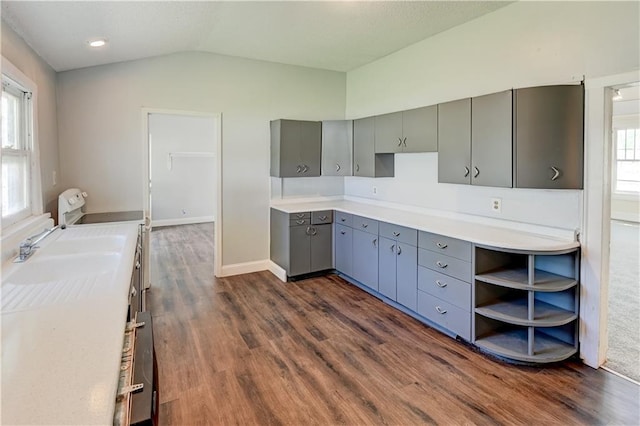 kitchen featuring light countertops, dark wood finished floors, lofted ceiling, open shelves, and gray cabinets