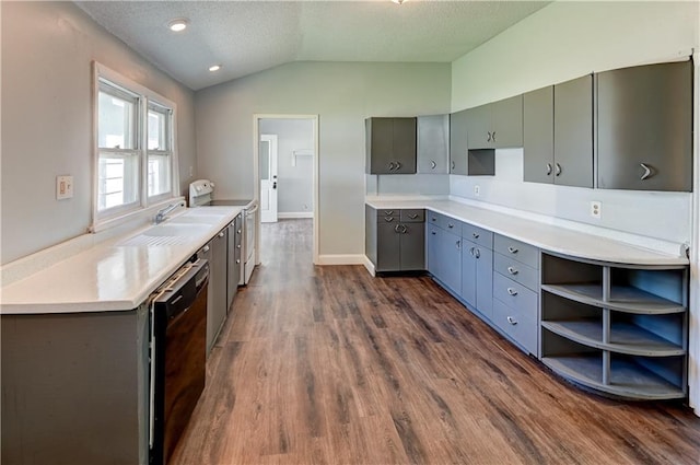 kitchen featuring a textured ceiling, black dishwasher, dark wood-type flooring, gray cabinetry, and vaulted ceiling