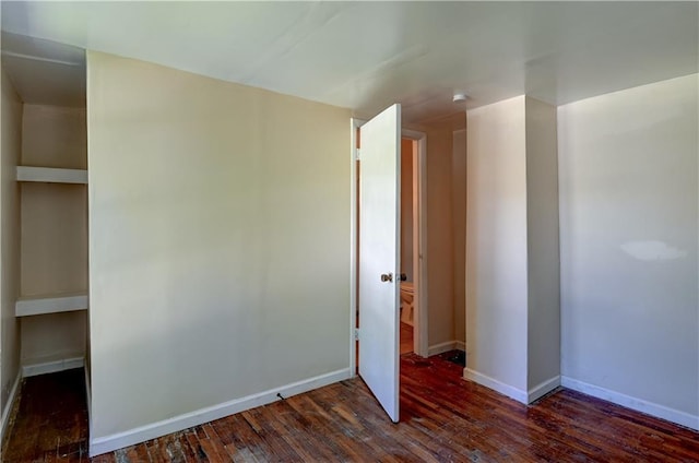empty room featuring baseboards and hardwood / wood-style flooring