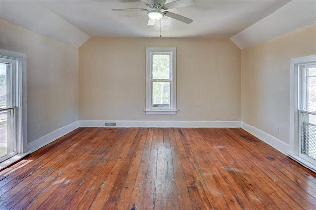 additional living space featuring hardwood / wood-style floors, baseboards, visible vents, and vaulted ceiling
