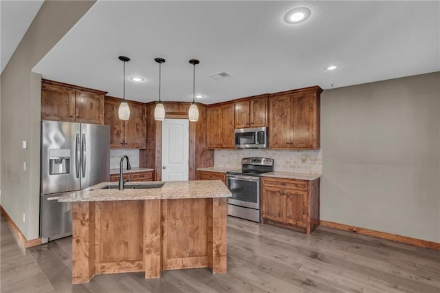 kitchen with light wood-type flooring, a sink, stainless steel appliances, and baseboards