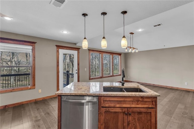 kitchen featuring visible vents, dishwasher, light wood finished floors, and a sink