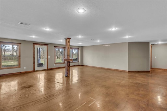 interior space with ornate columns, visible vents, baseboards, and plenty of natural light