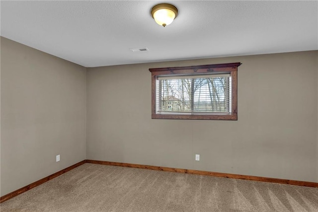 spare room featuring visible vents, light carpet, and baseboards