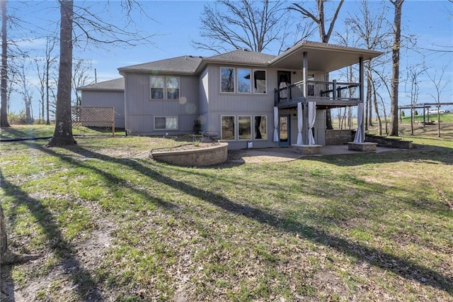 rear view of house featuring a lawn, a patio, a balcony, and a shingled roof