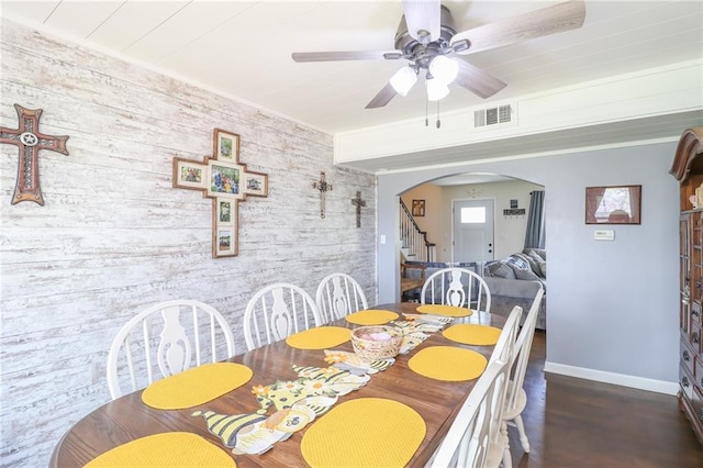dining area with baseboards, stairway, a ceiling fan, visible vents, and arched walkways