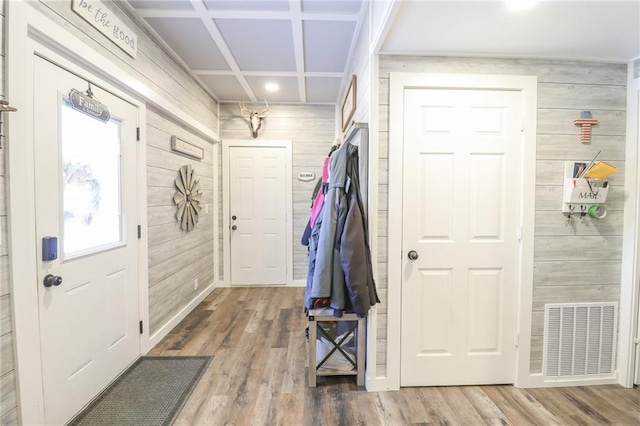 entrance foyer with coffered ceiling, wood finished floors, wood walls, and visible vents