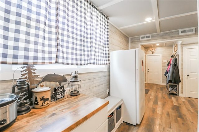 mudroom featuring wooden walls, visible vents, and wood finished floors