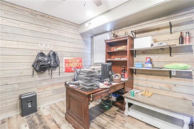 home office with wooden walls and wood finished floors