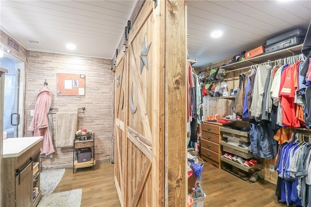interior space featuring wood finished floors, visible vents, and a barn door