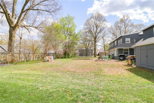 view of yard featuring a storage shed, a trampoline, and an outdoor structure