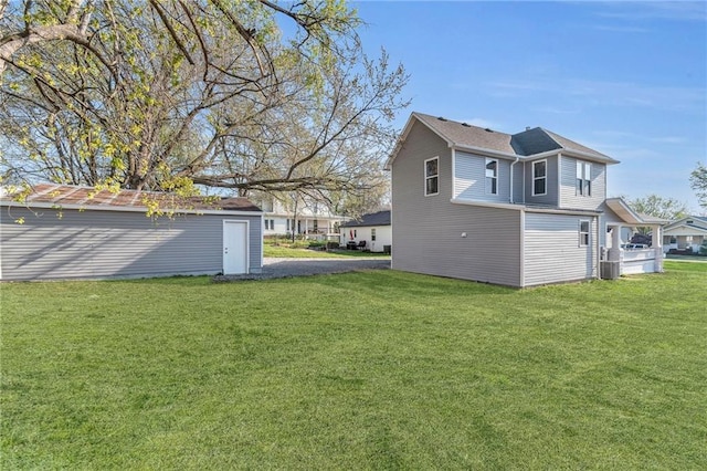 613 N Mead St, Cameron, MO 64429 - view of side of home with a lawn, an outbuilding, and cooling unit