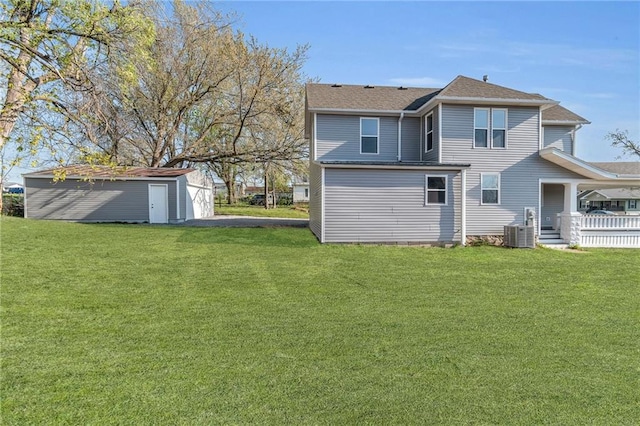 613 N Mead St, Cameron, MO 64429 - rear view of house with central air condition unit, a lawn, and an outbuilding