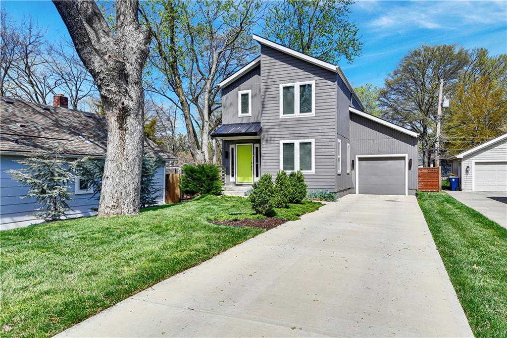 102 E 81st St, Kansas City, MO 64114 - mid-century modern home with a front yard, driveway, and an attached garage