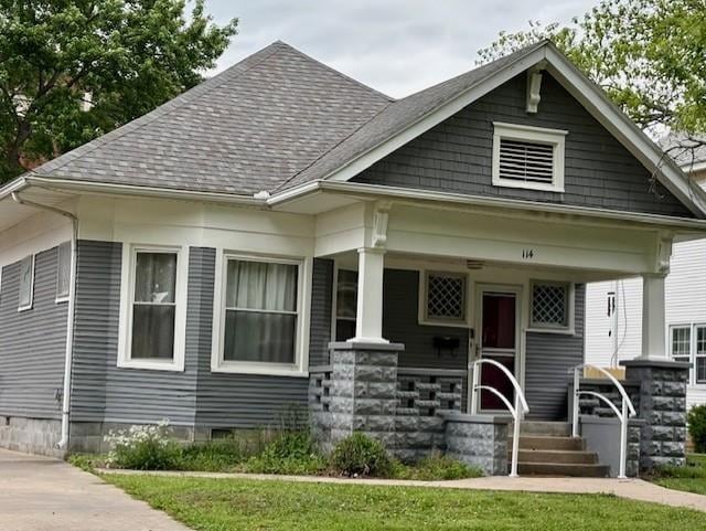 view of front facade with covered porch and a shingled roof