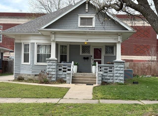 view of front facade featuring a porch, crawl space, and roof with shingles