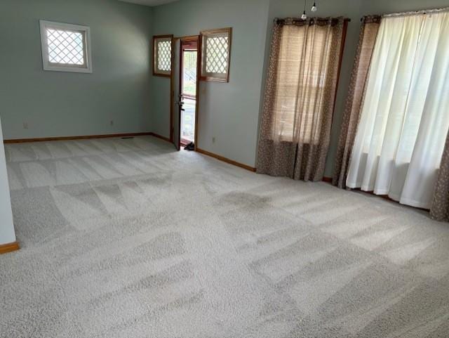 carpeted empty room featuring baseboards
